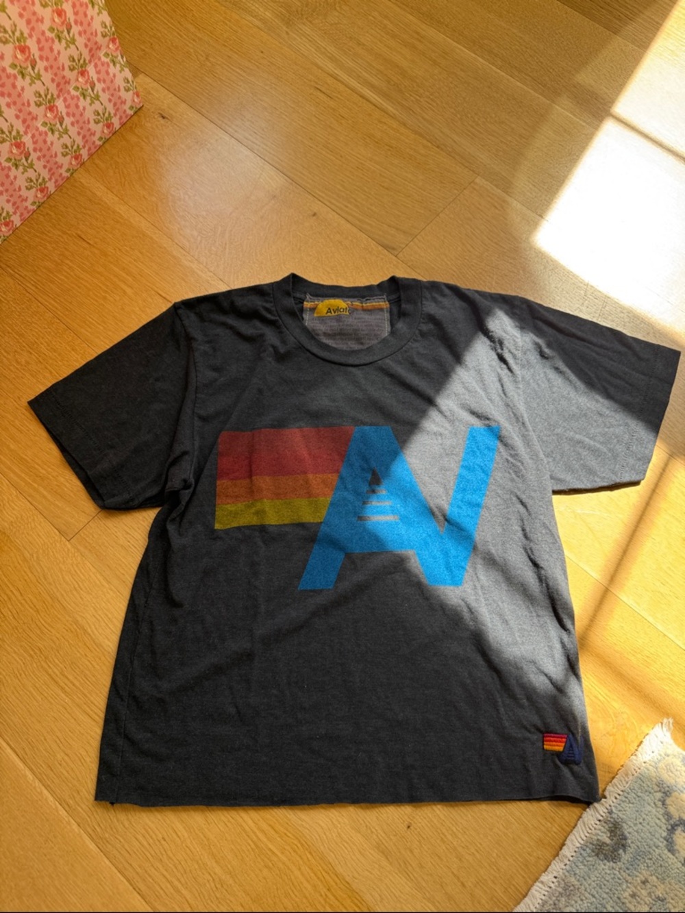 Aviator Nation Black Tee with Blue 'AV' Logo and Red-Yellow Stripe